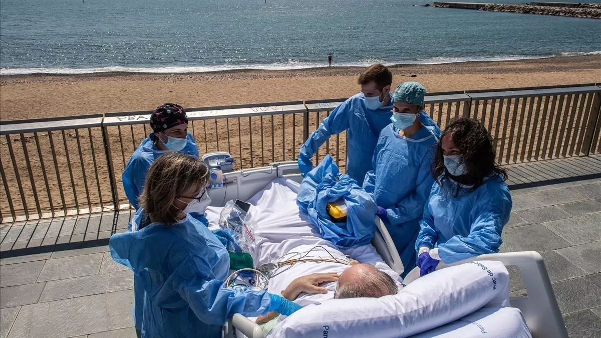 isidre-correa-junto-mujer-equipo-medico-frente-playa-delante-del-hospital-del-mar-barcelona-1591205325306
